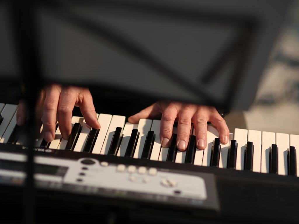 Hände auf den Tasten eines E-Pianos